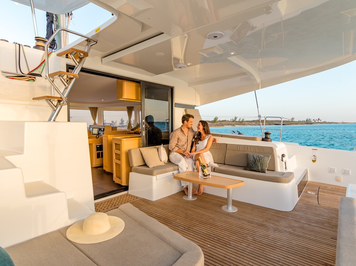 Guests relaxing in the catamaran's outdoor aft lounge